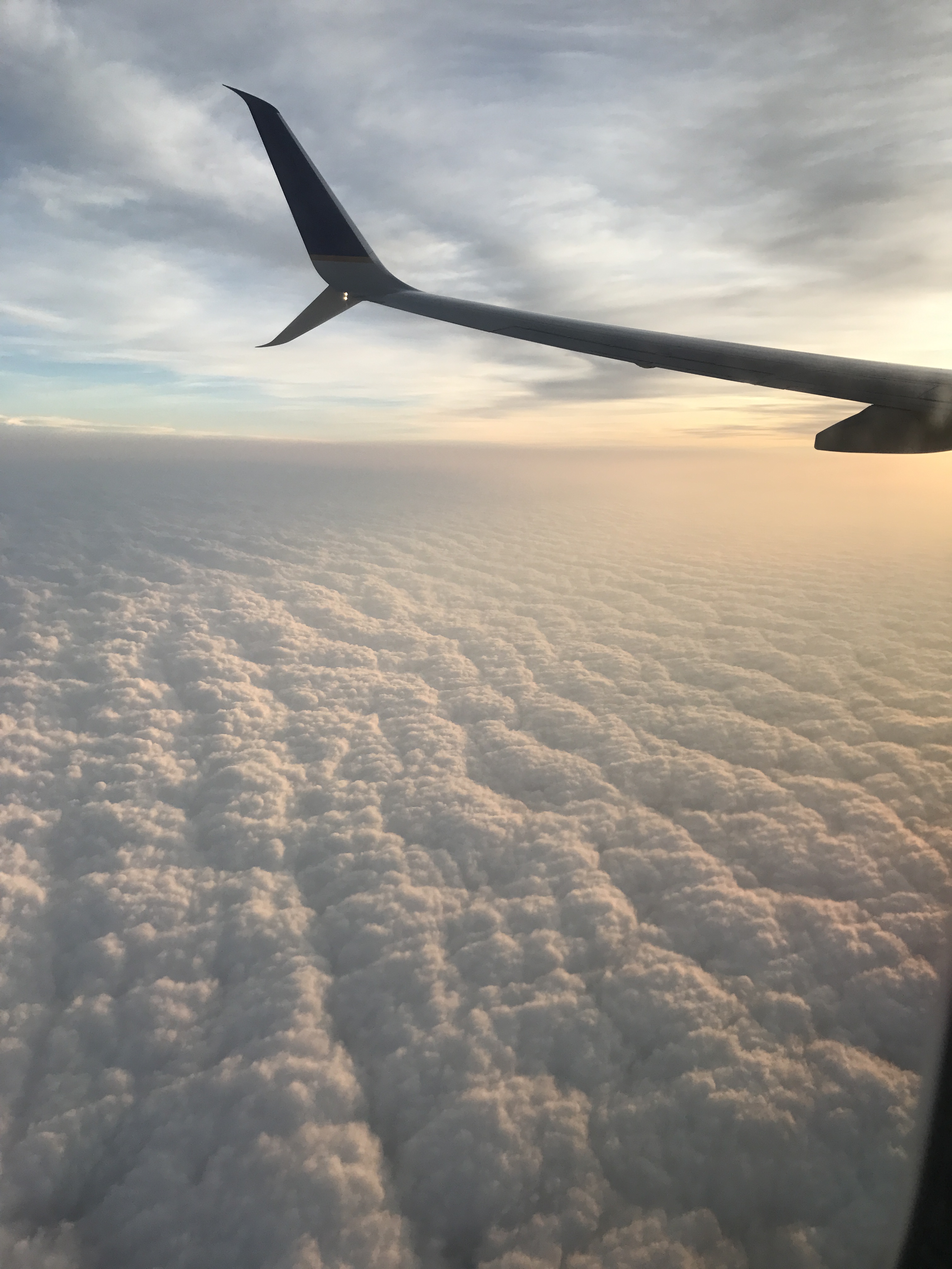 View from a plane window. Airplane wing over a cover of clouds