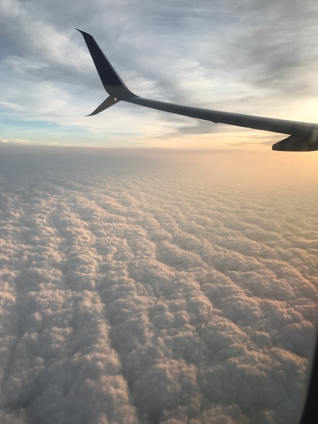 View from a plane window. Airplane wing over a cover of clouds